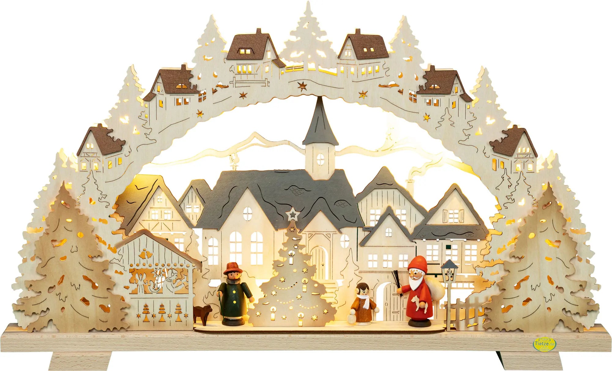 LED‑beleuchteter Schwibbogen mit Motiv ›Adventszeit in der Kleinstadt‹: Dargestellt ist eine winterliche Stadtansicht mit beleuchteten Häusern, Kirche und verschneiten Bäumen. Im Vordergrund stehen farbig bemalte Hennigfiguren, darunter ein Weihnachtsmann, ein Kind und eine weitere Figur neben einem geschmückten Weihnachtsbaum. Warmes, gelbes LED‑Licht beleuchtet die Szene und erzeugt eine festliche Atmosphäre. – Frontalansicht und beleuchtet