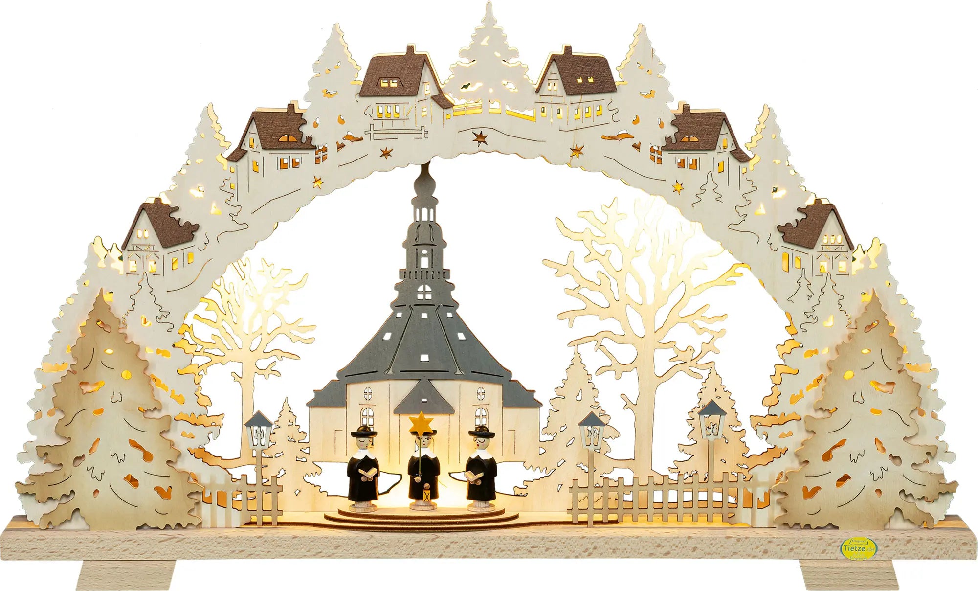 Beleuchteter Holz‑Schwibbogen mit der Seiffener Kirche, umgeben von Tannen, Dorfhäusern im Bogen und drei Kurrende‑Figuren im Vordergrund. LED Schwibbogen "Seiffener Kirche" – Frontal beleuchtet