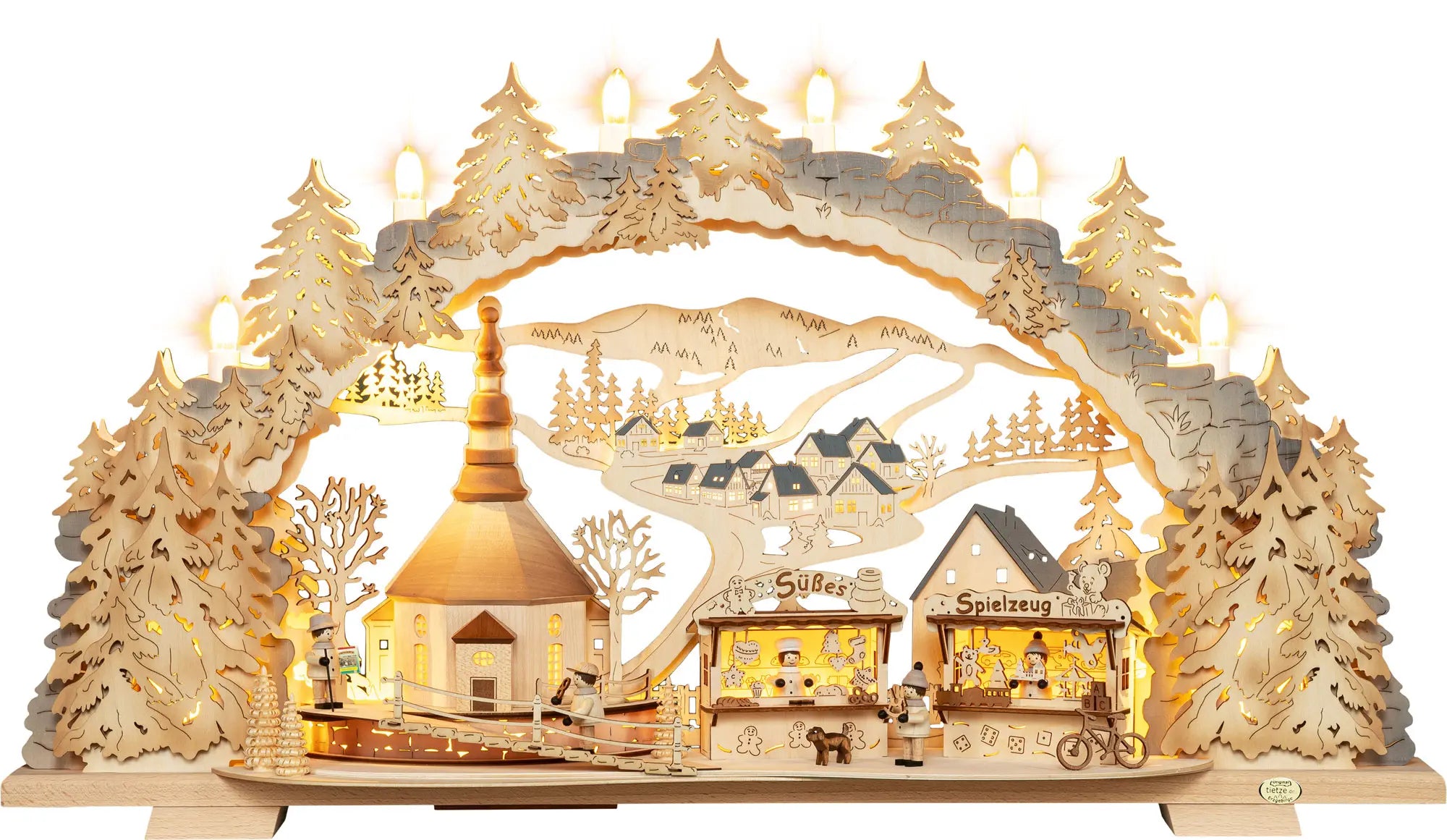Beleuchteter Holz‑Schwibbogen mit Kirmes‑Motiv in Seiffen, Kirche, Marktständen, kleinen Figuren und winterlicher Landschaft. LED Schwibbogen "Kirmes in Seiffen" – Frontale Ansicht und beleuchtet.