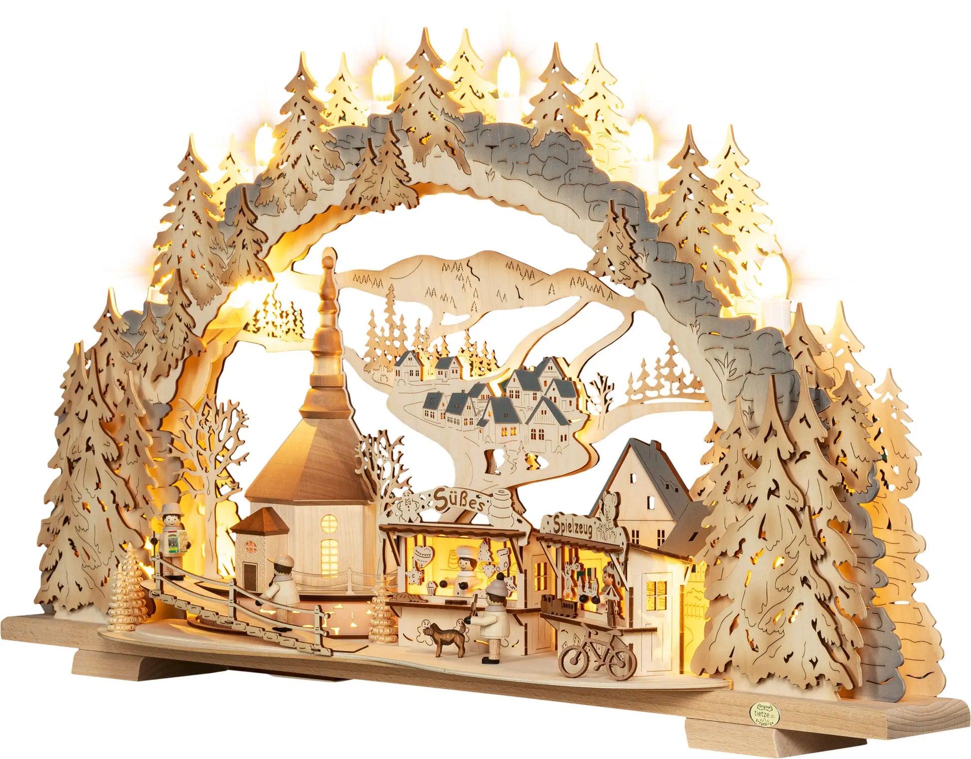 Beleuchteter Holz‑Schwibbogen mit Kirmes‑Motiv in Seiffen, Kirche, Marktständen, kleinen Figuren und winterlicher Landschaft. LED Schwibbogen "Kirmes in Seiffen" – 45° Ansicht von links