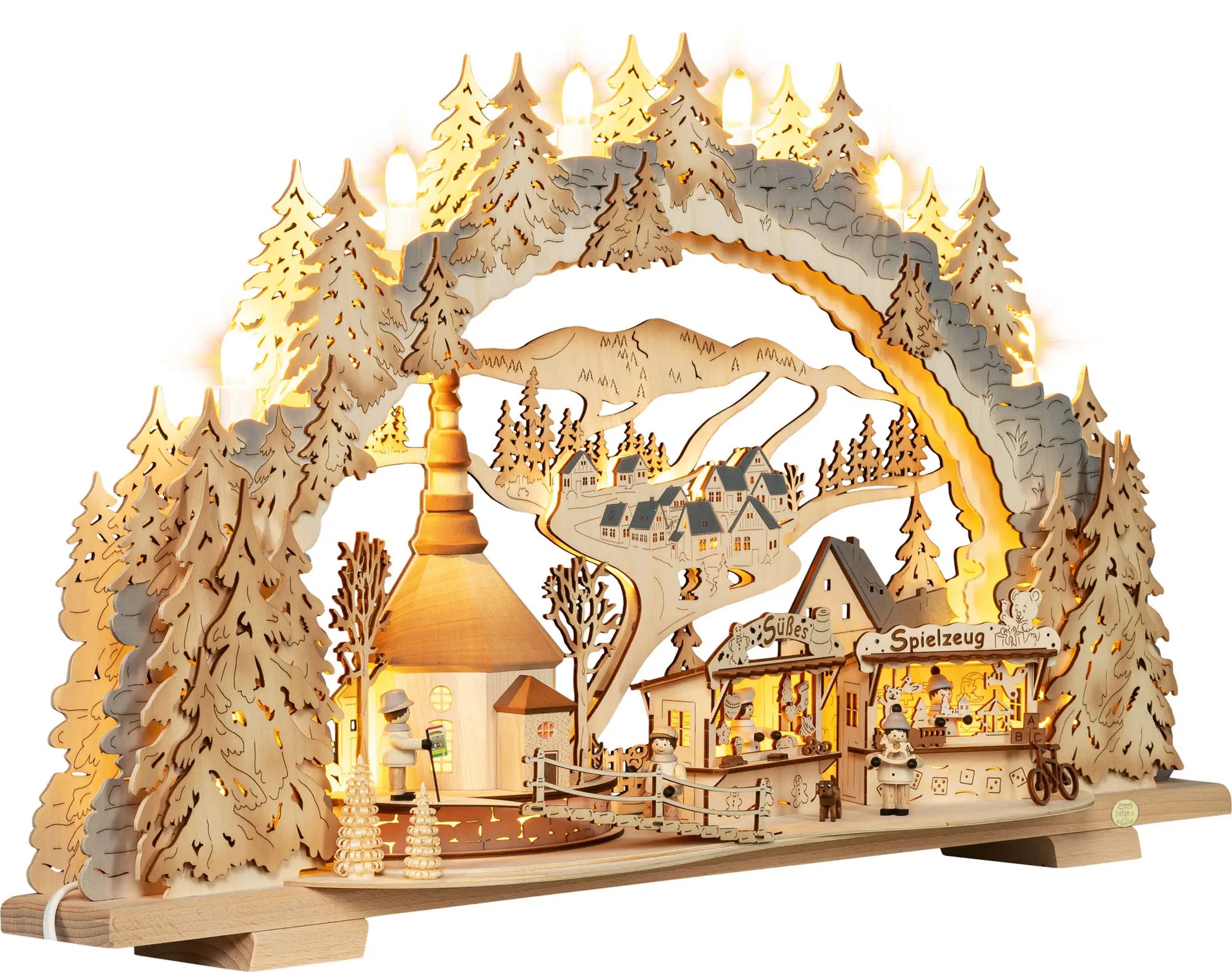 Beleuchteter Holz‑Schwibbogen mit Kirmes‑Motiv in Seiffen, Kirche, Marktständen, kleinen Figuren und winterlicher Landschaft. LED Schwibbogen "Kirmes in Seiffen" – 45° Ansicht von rechts